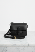 Elegant front view of Céline black structured leather crossbody bag with tab closure and gold buckle